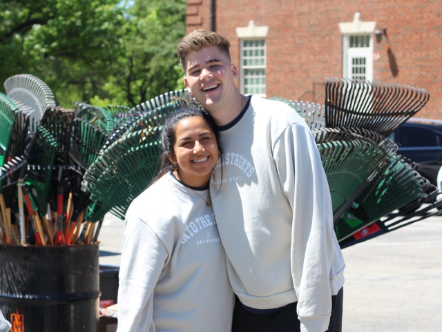 Volunteers standing and smiling next to rakes